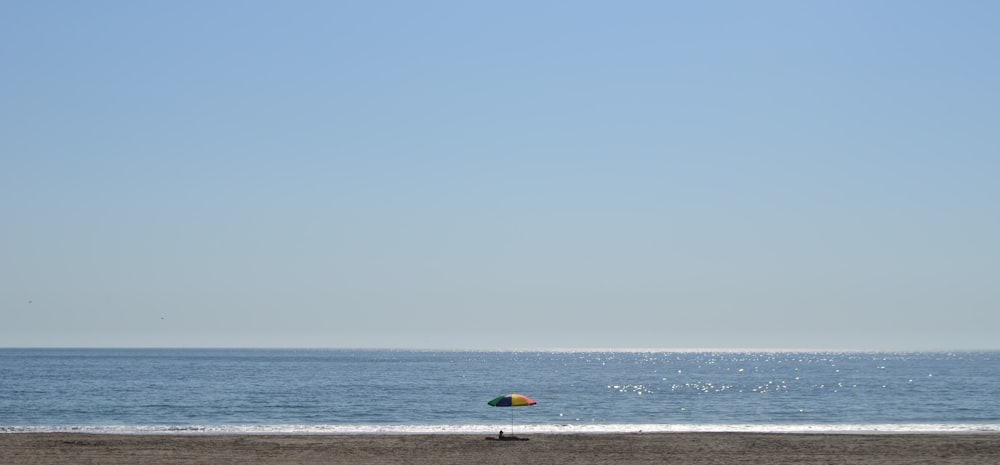 a person on a beach flying a kite