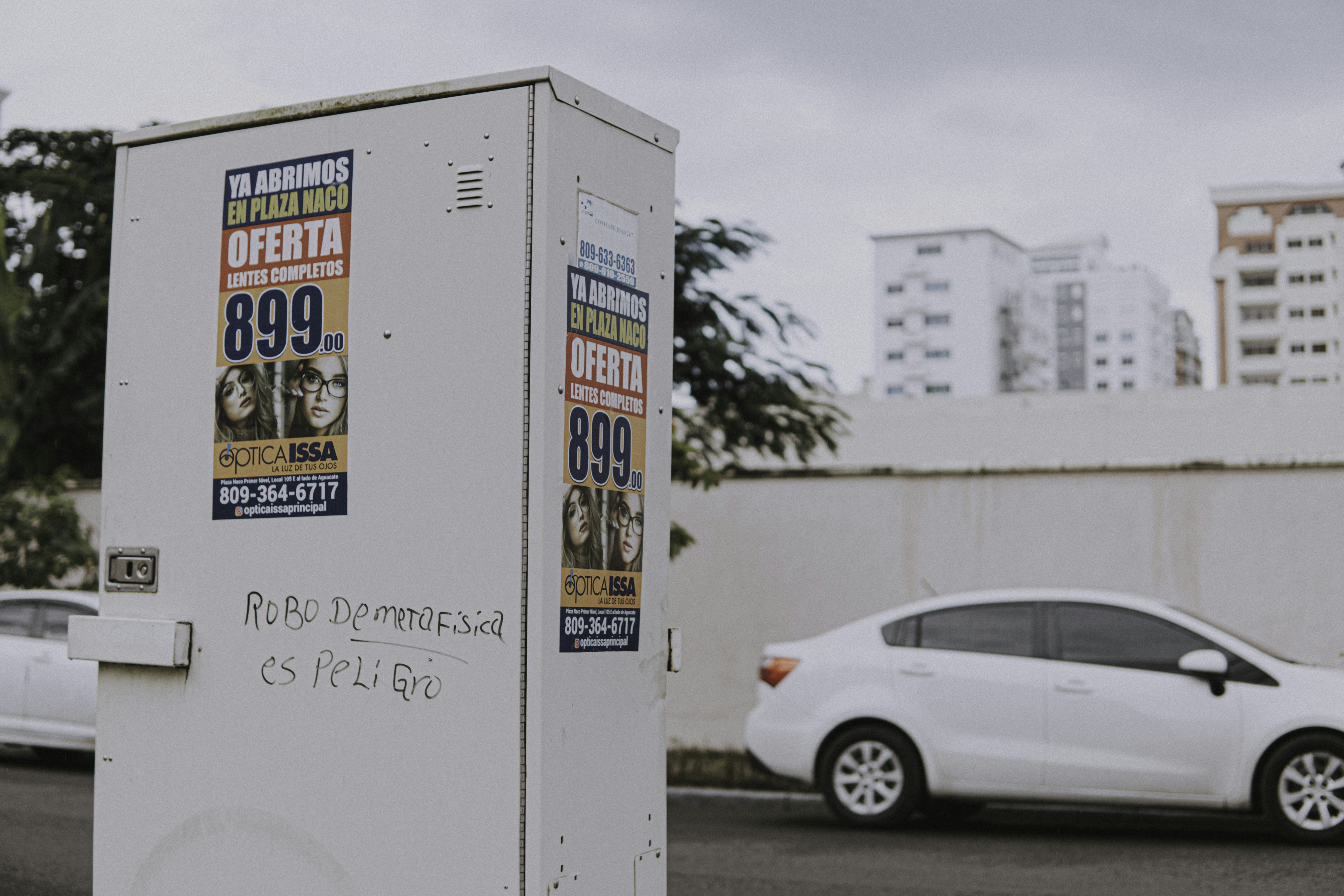 a white box sitting on the side of a road