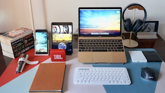 a laptop computer sitting on top of a desk next to a keyboard