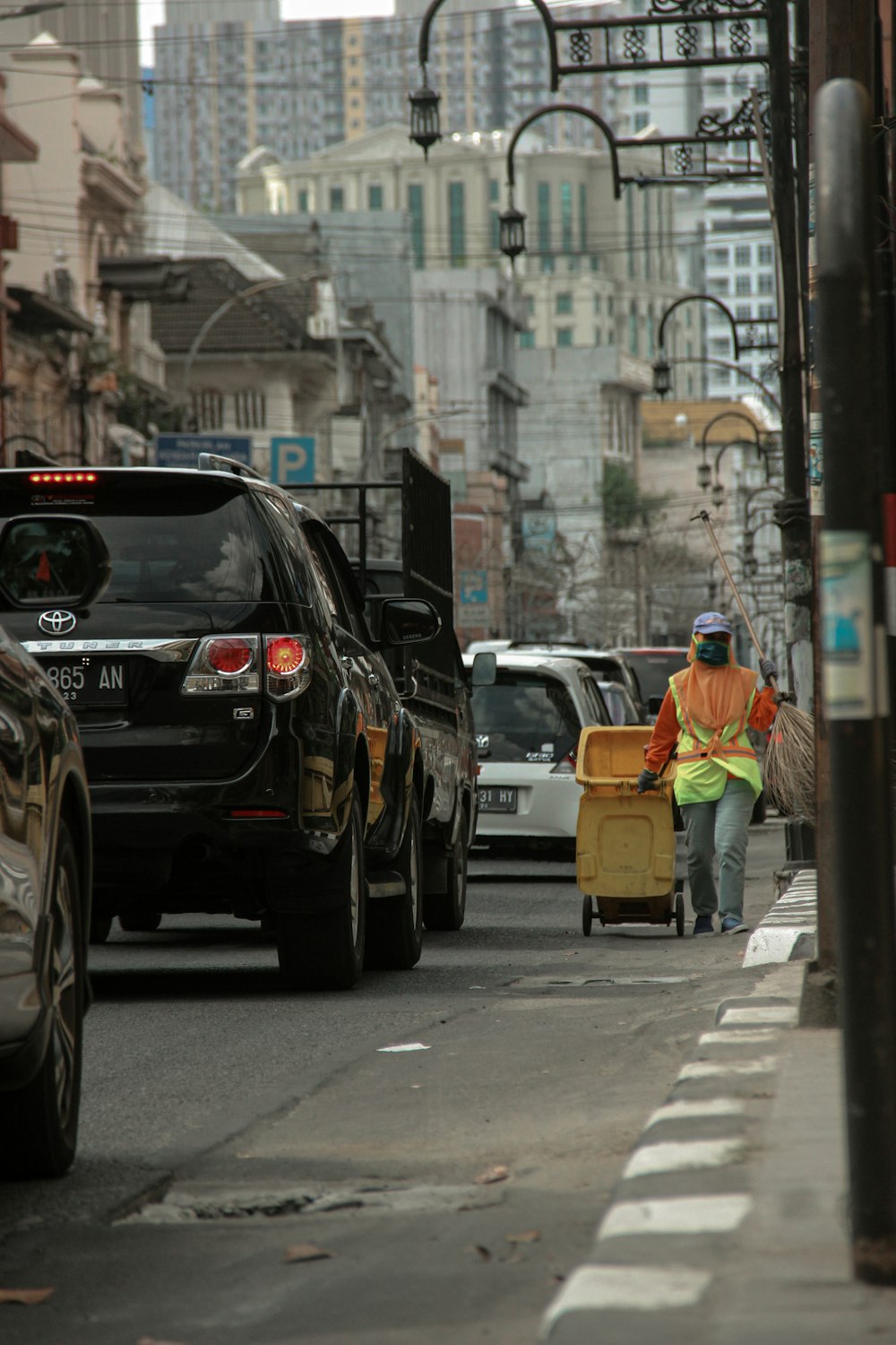 Ein Mann zieht einen Koffer eine belebte Straße der Stadt hinunter