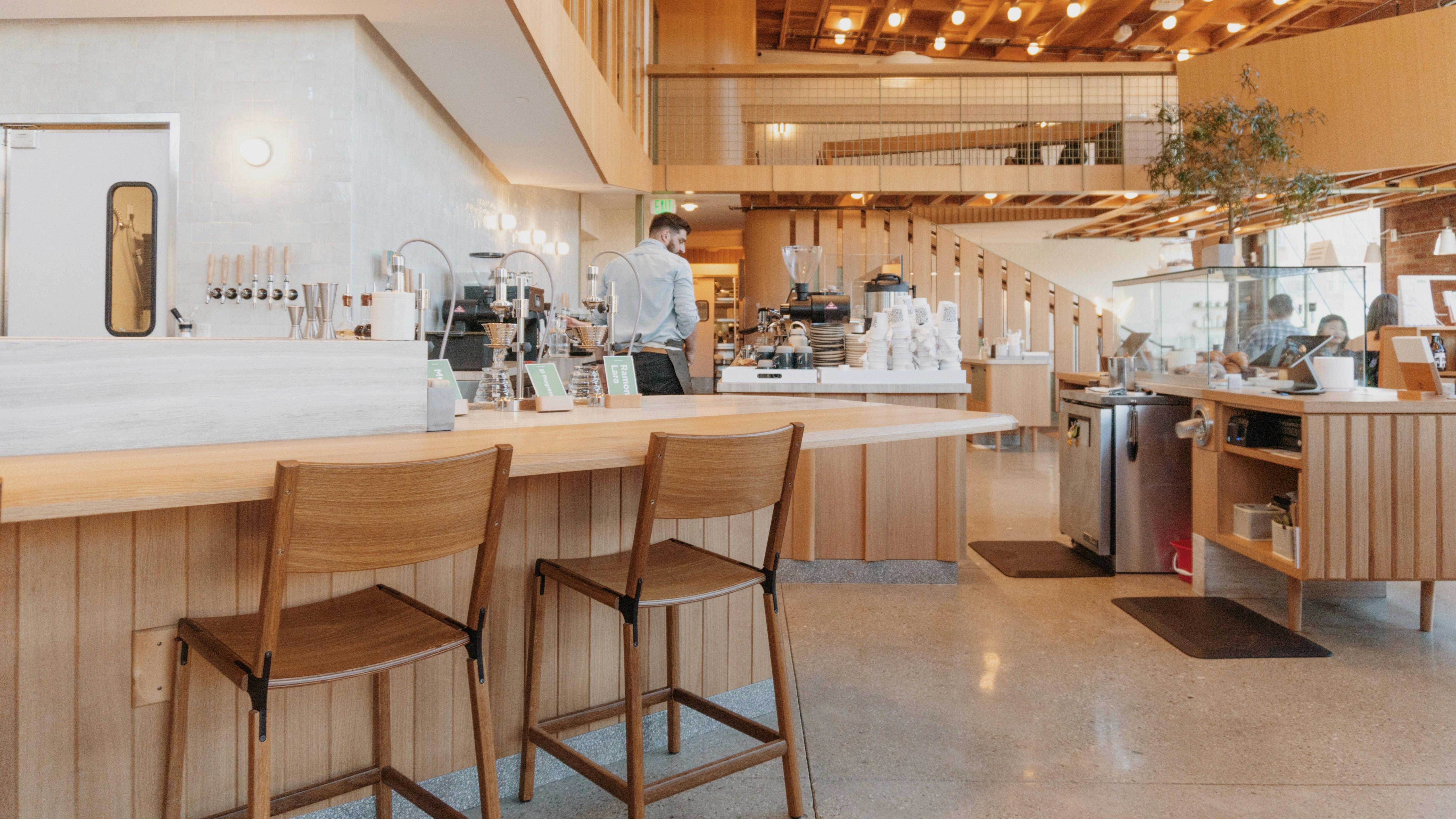 a restaurant with a long counter and wooden chairs, 