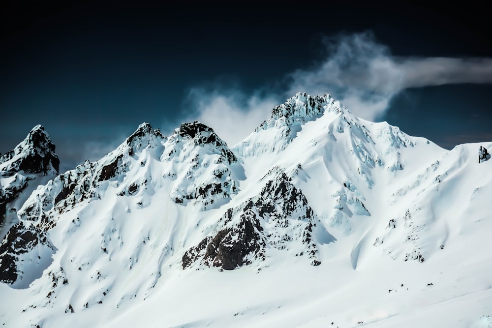 Una montagna coperta di neve sotto un cielo nuvoloso