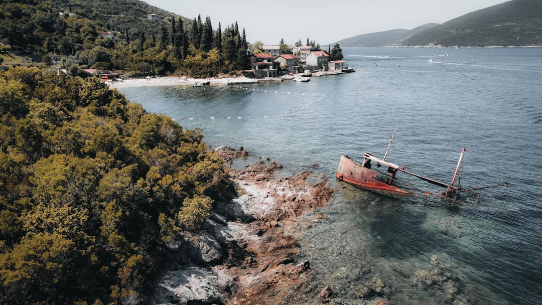 a boat in a body of water near a shore, Shipwreck Beach in Rose to the entrance to the Bay of Kotor.