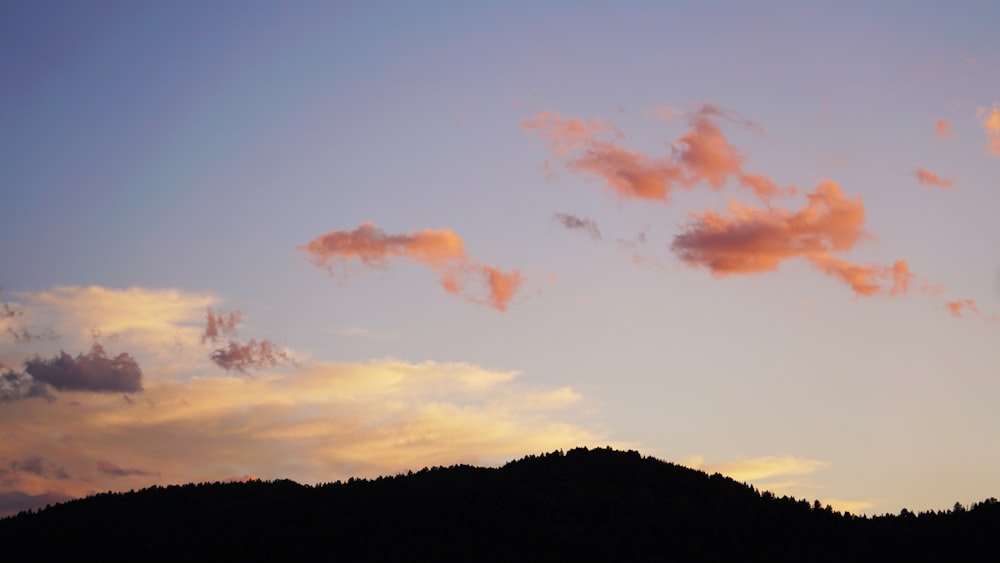 a plane flying in the sky over a mountain