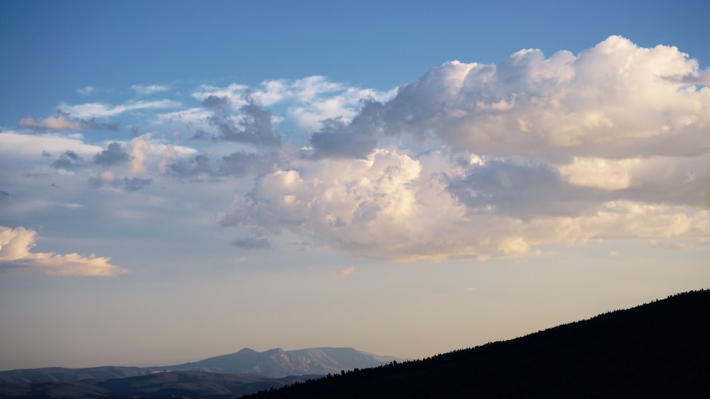 Una grande nuvola è nel cielo sopra una montagna