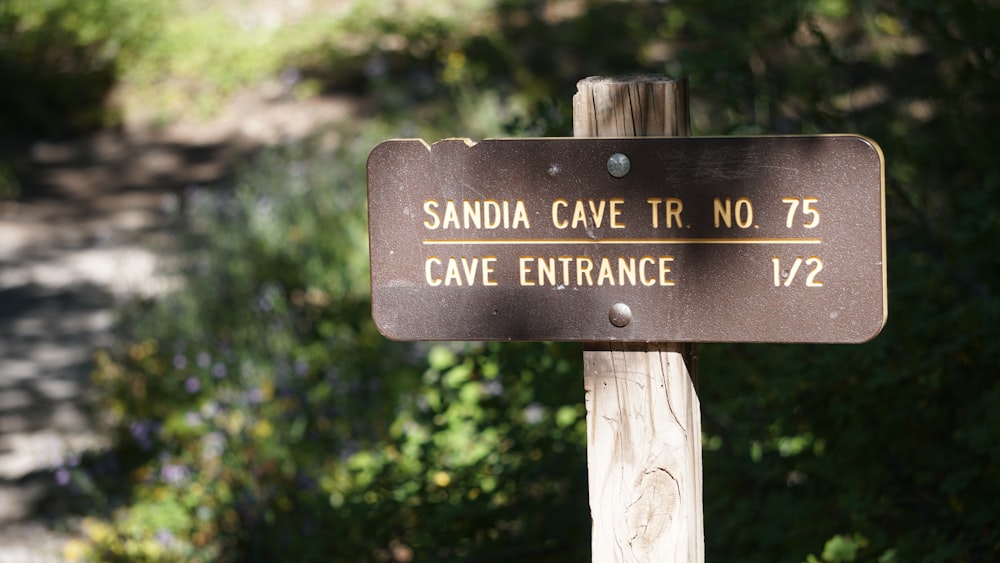Un letrero de madera que dice Sandia Cave TRR No 75 Cave Entrance