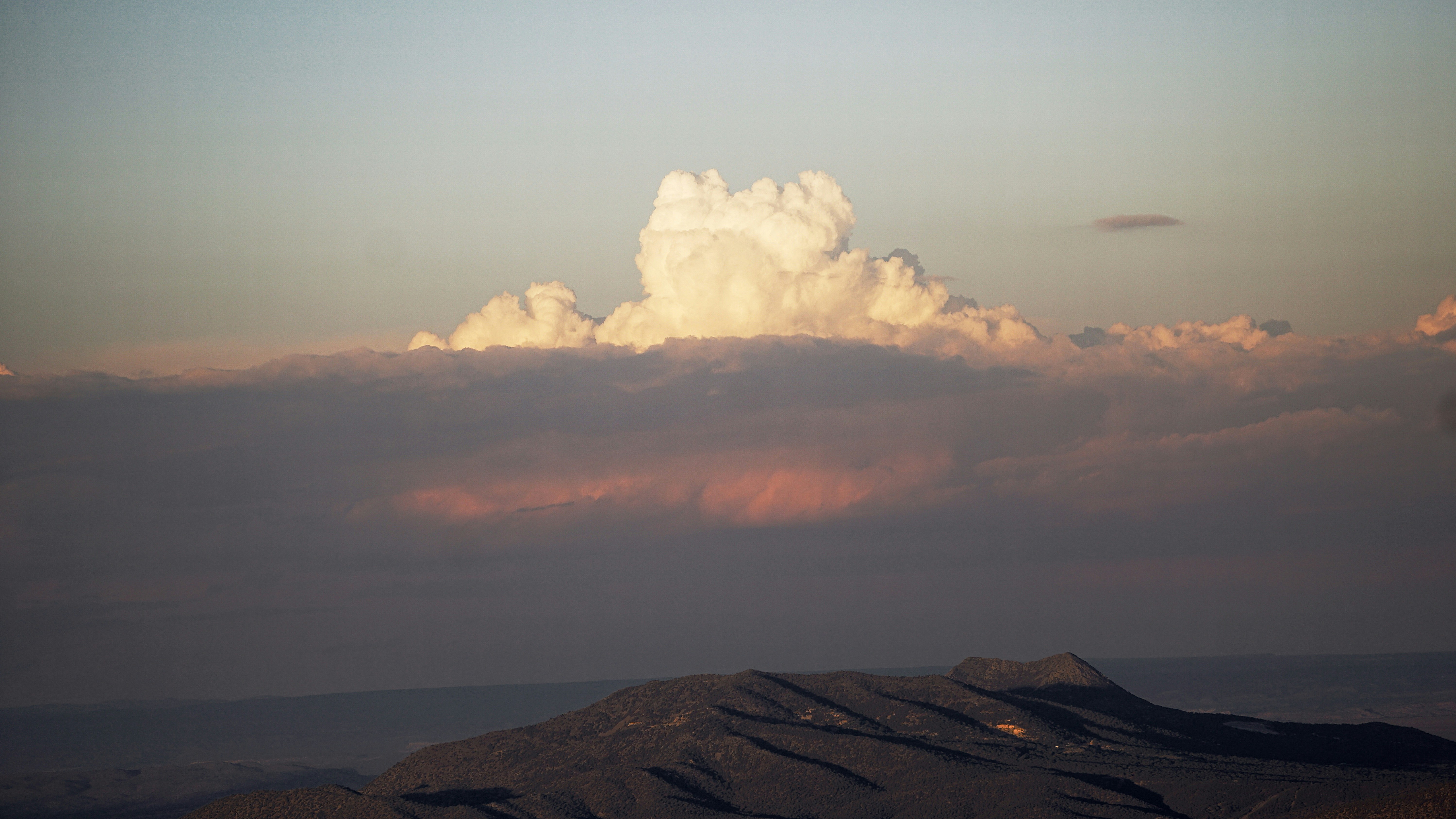 Eine große Wolke ist am Himmel über einem Berg