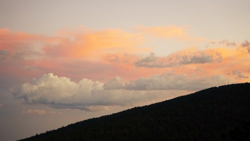 uma montanha com algumas nuvens no céu