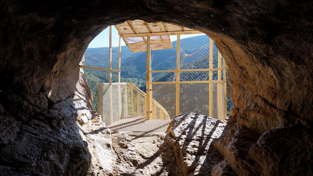 a view from inside a cave looking out at mountains