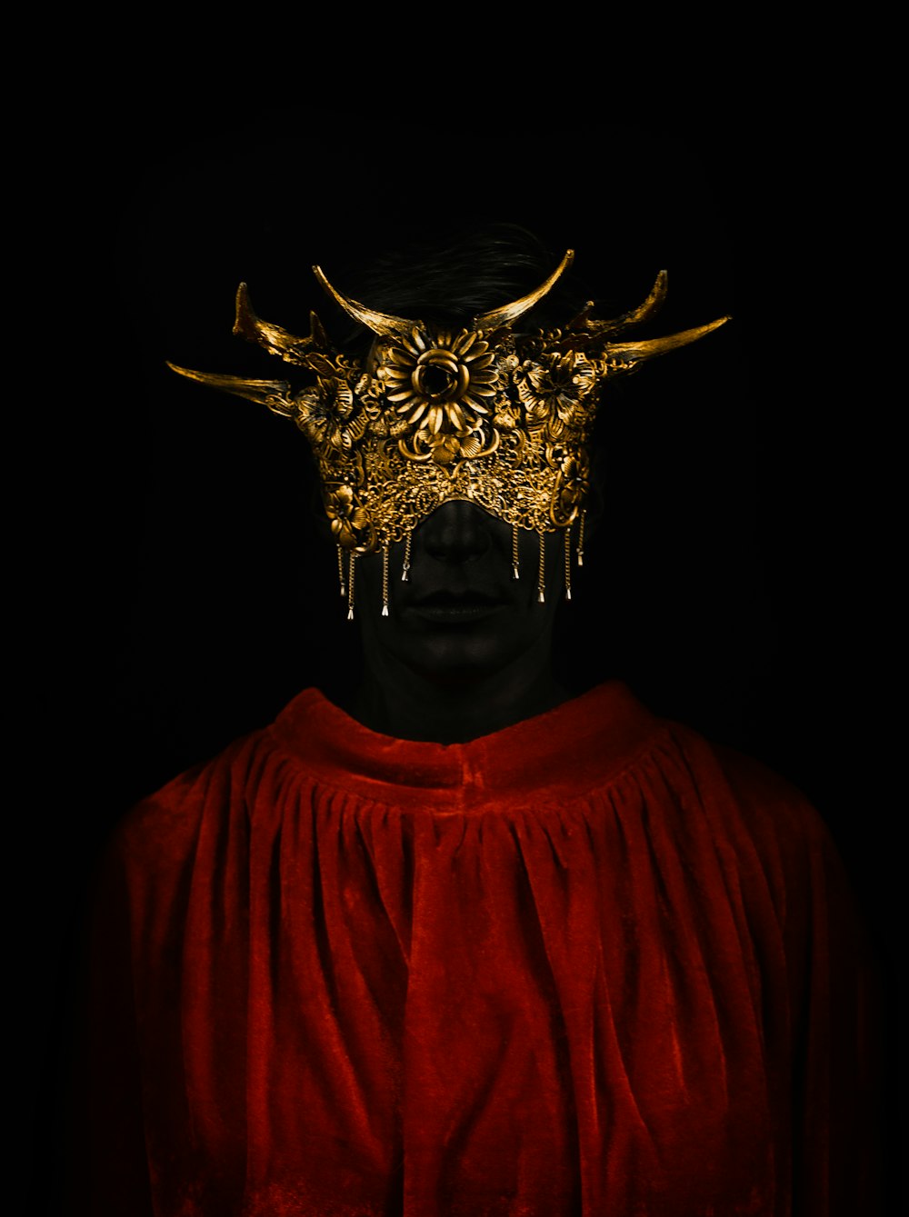 a man in a red cape with horns on his head