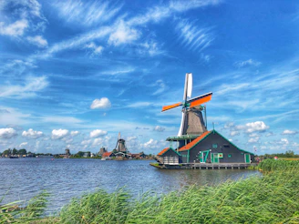 a windmill sitting on top of a body of water Netherlands