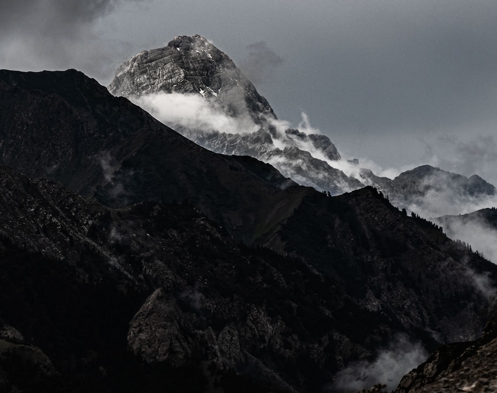 a very tall mountain covered in clouds in the distance