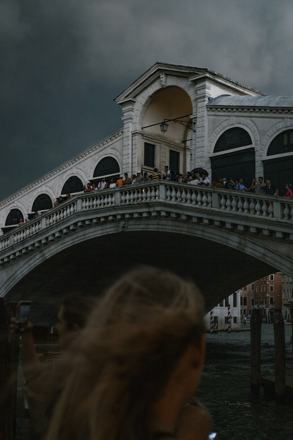 Una multitud de personas de pie en la cima de un puente