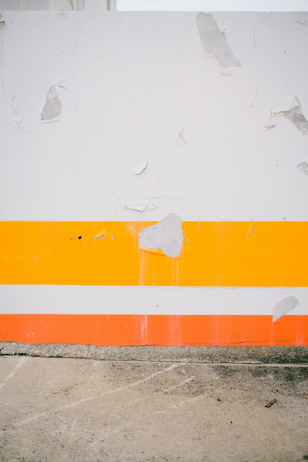 an orange and white striped wall with a fire hydrant