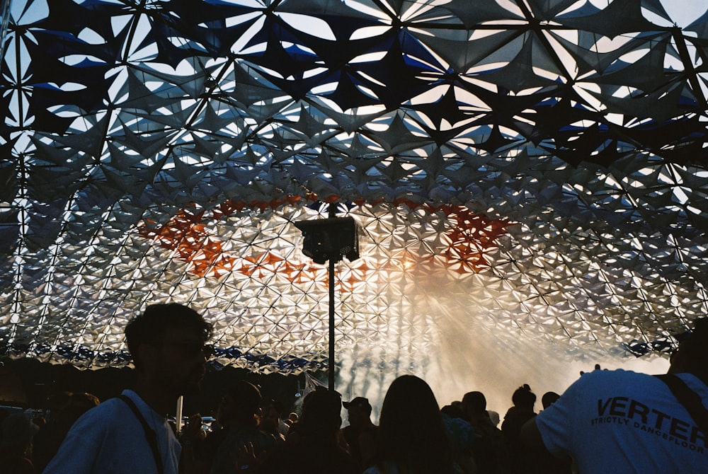 a group of people standing under a metal structure