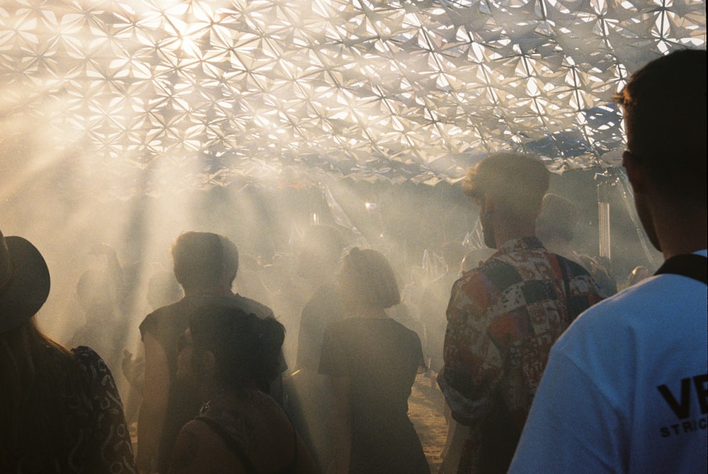 a group of people standing under a metal structure