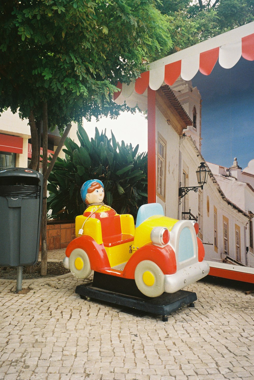 Une statue d’un garçon conduisant une petite voiture