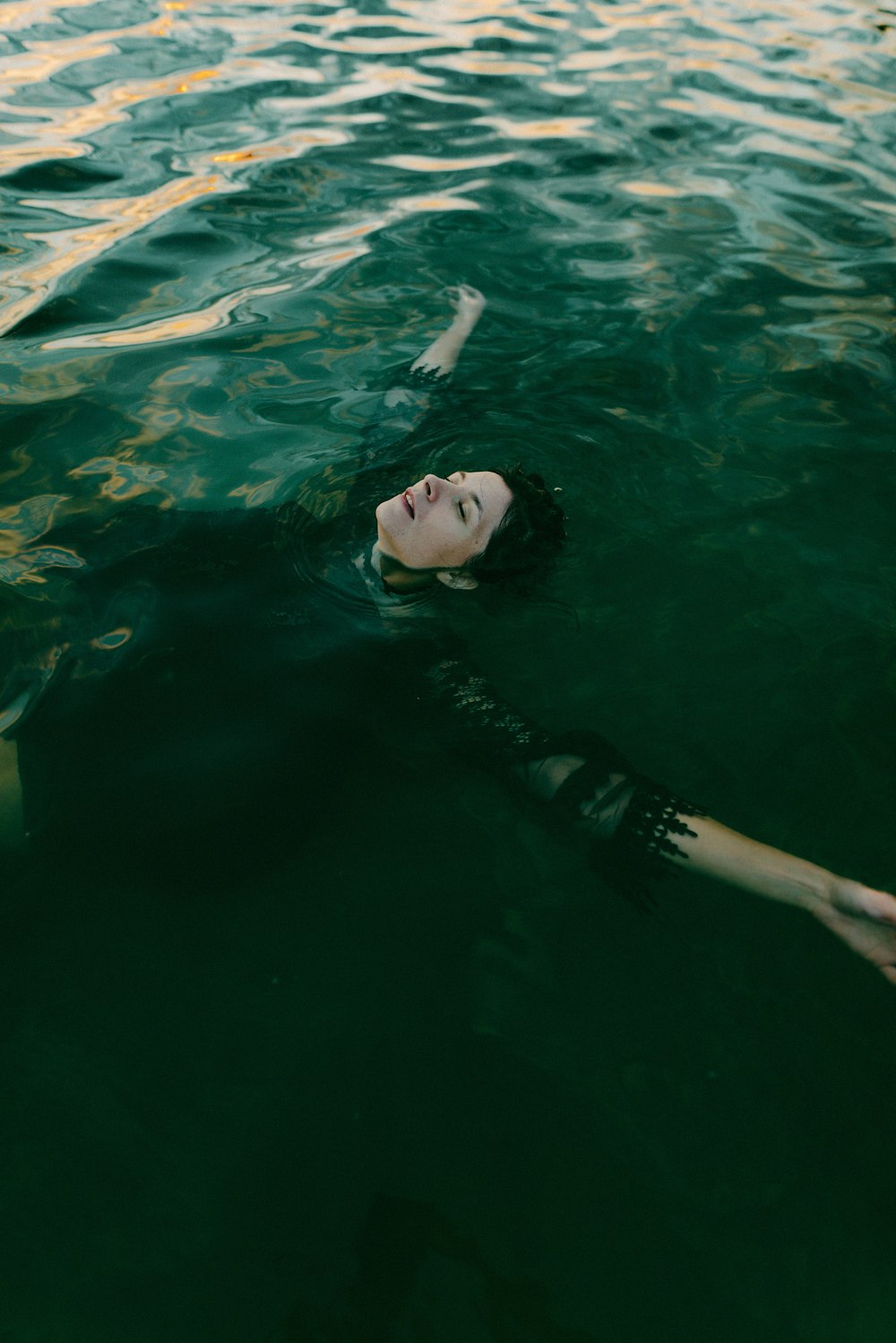 a woman floating on top of a body of water