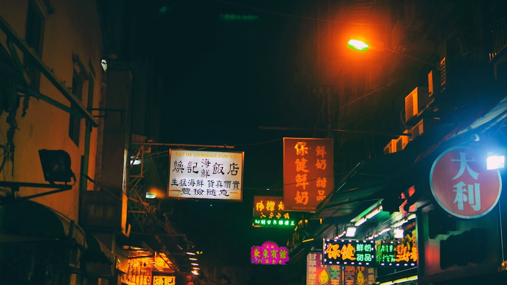 Una calle de la ciudad por la noche con letreros de neón