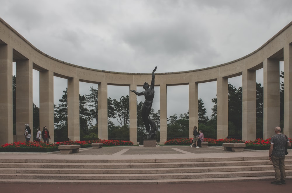 Un homme debout devant une statue