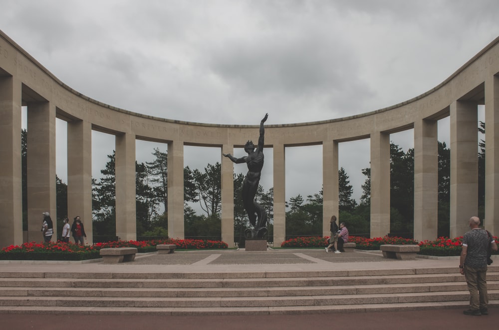 Un hombre parado frente a una estatua