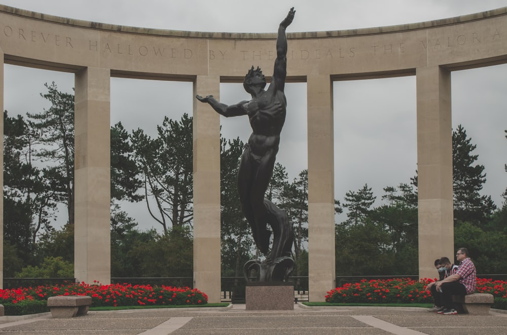 a woman sitting on a bench next to a statue