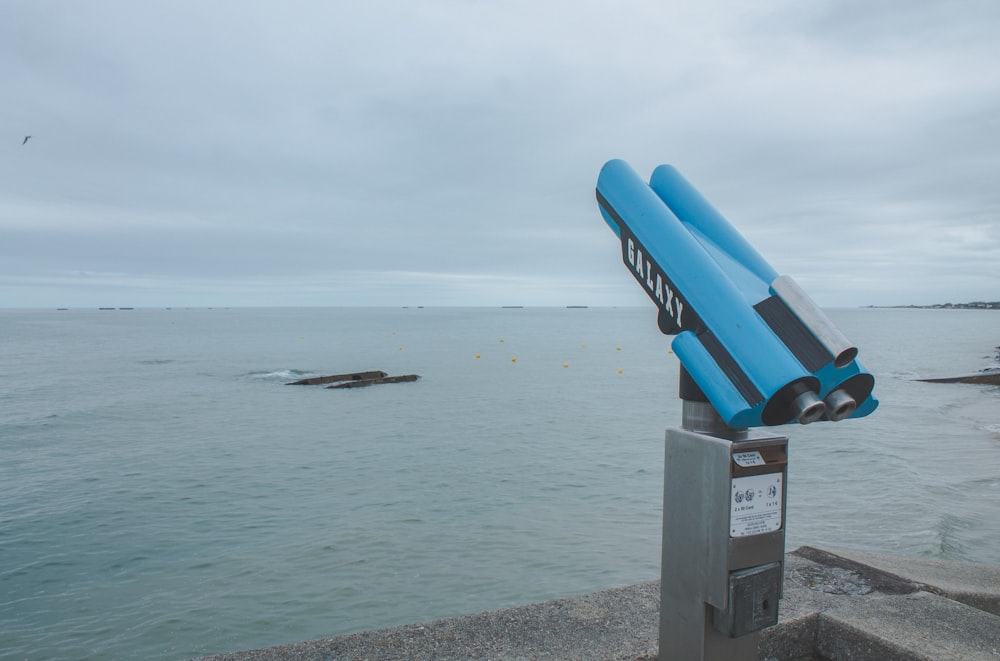 a pair of blue binoculars sitting on top of a metal box