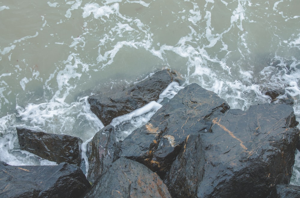 a view of the ocean from above rocks