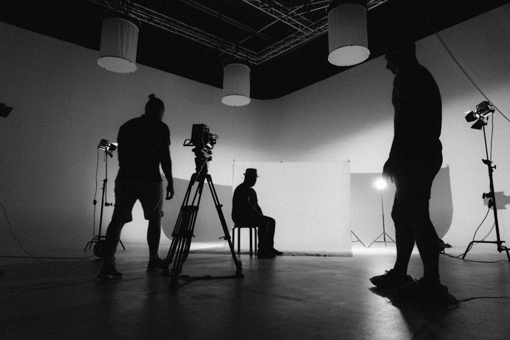 a black and white photo of a man standing in front of a camera