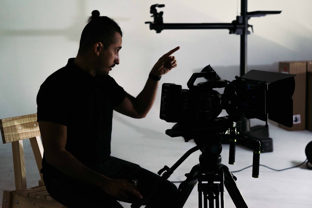 a man sitting on a chair in front of a camera