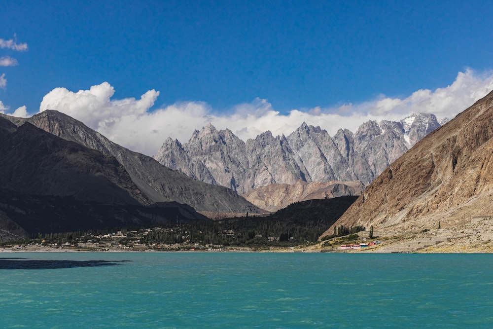 a lake surrounded by mountains under a blue sky