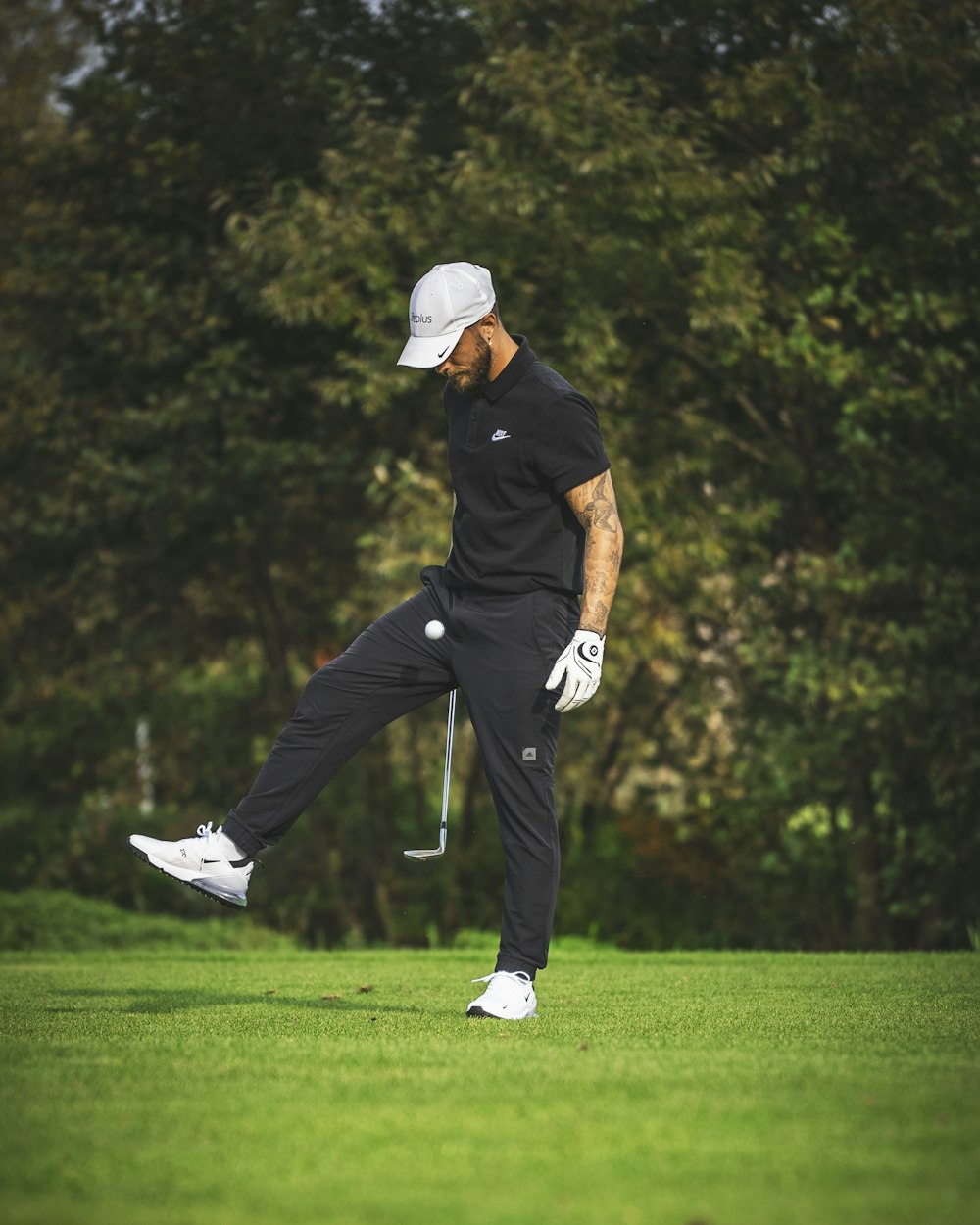 a man swinging a golf club on top of a green field