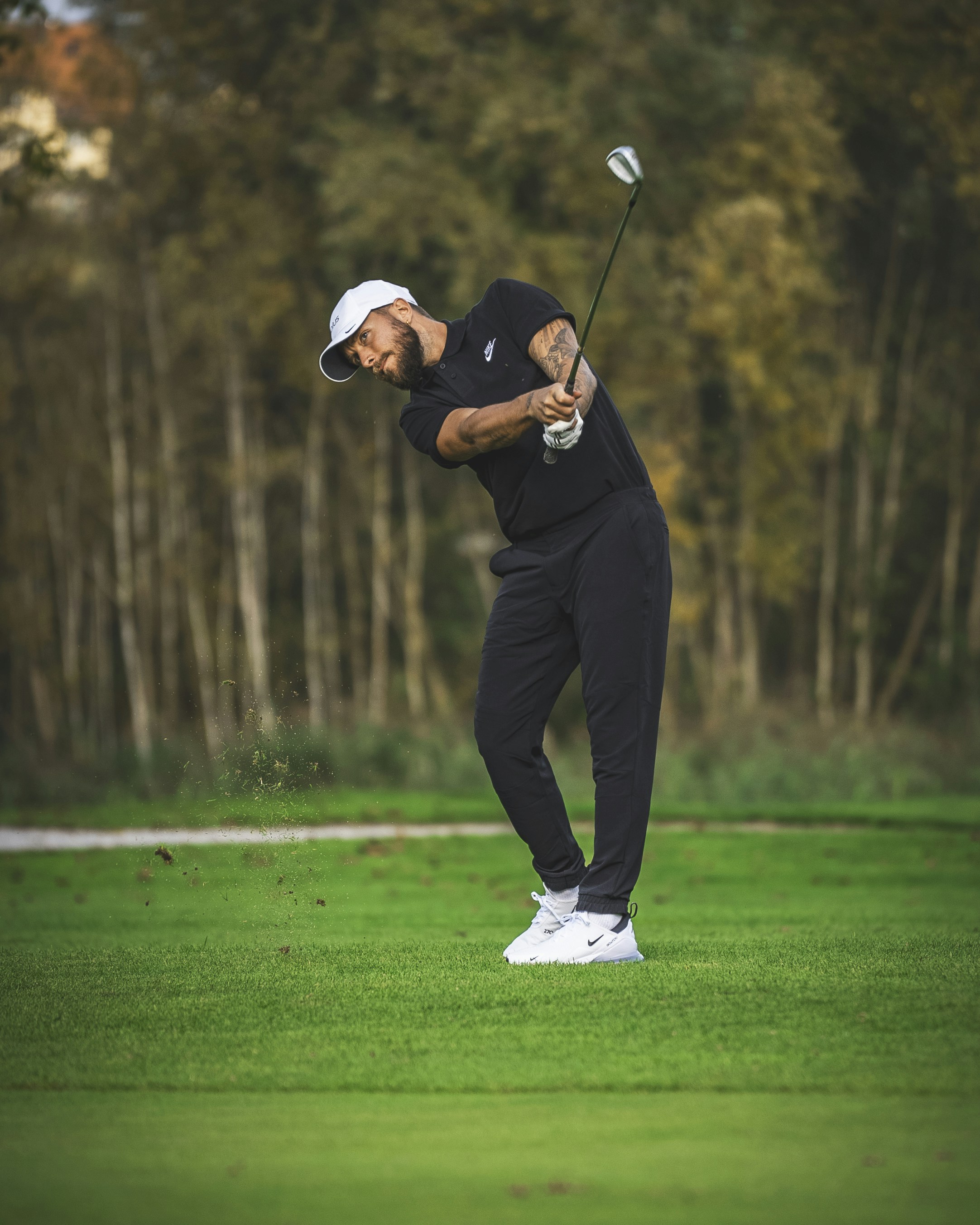 Un homme frappant une balle de golf avec un club de golf