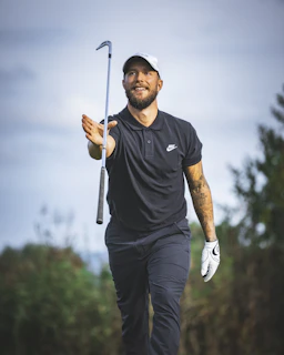 a man holding a golf club and a golf ball