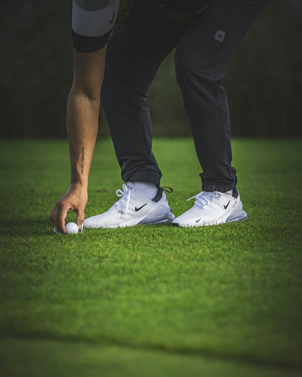 a man putting a golf ball in the grass