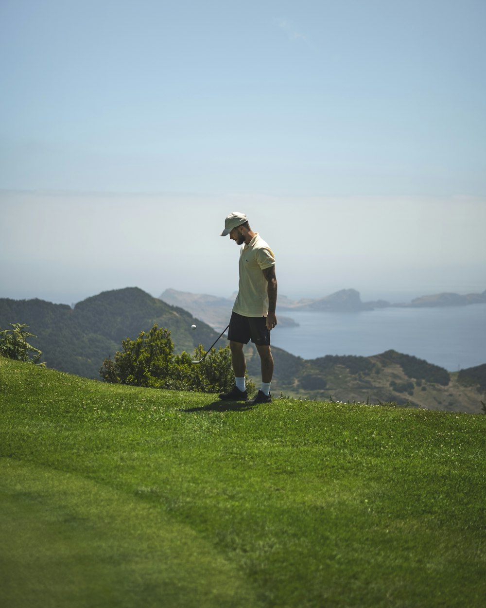 a man standing on top of a lush green hillside