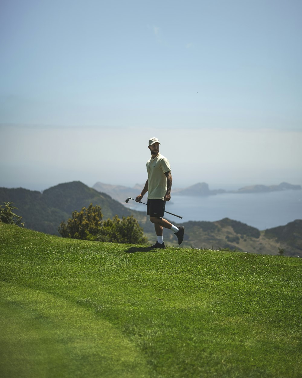 a man walking across a lush green field