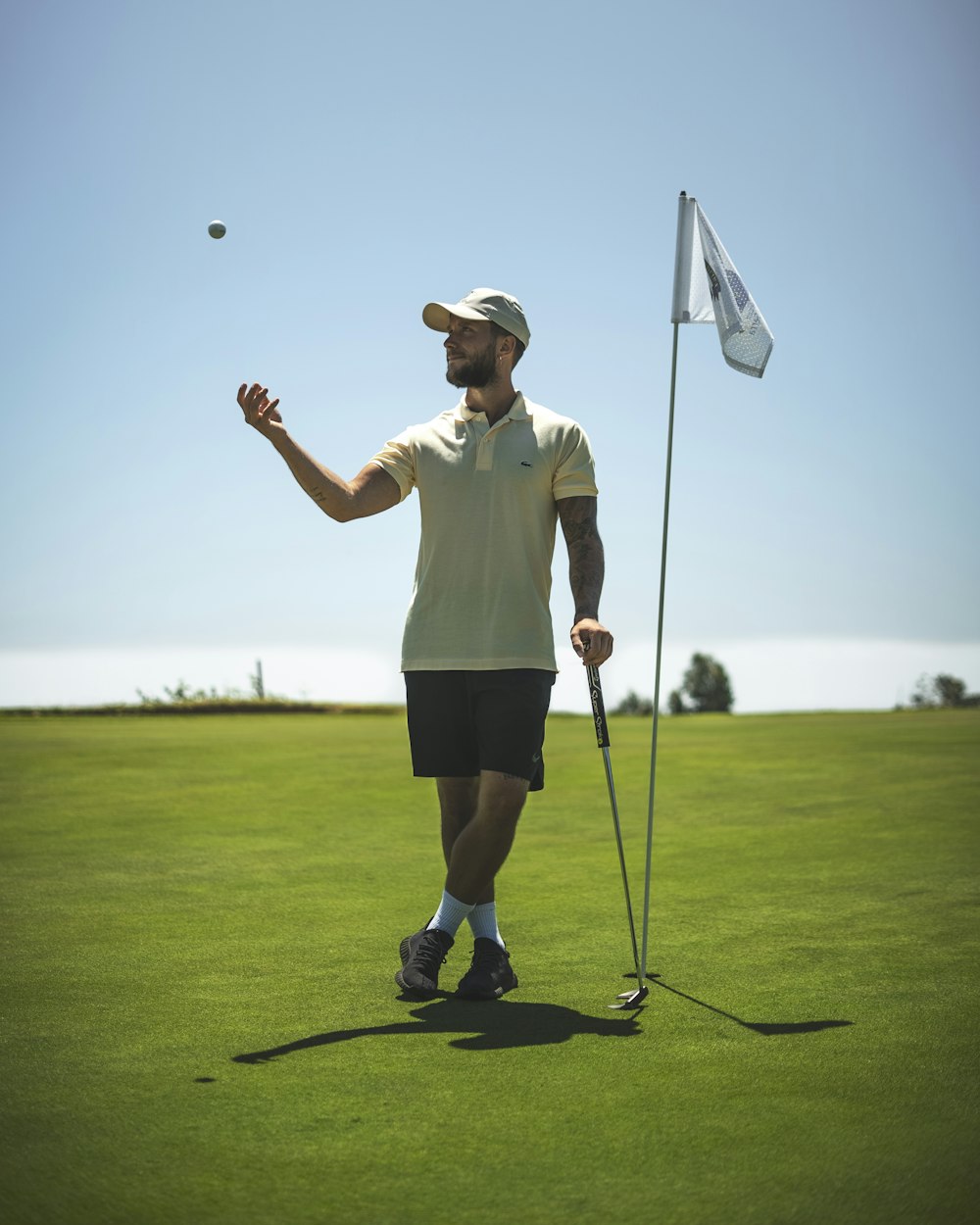 a man standing on top of a green field holding a golf club