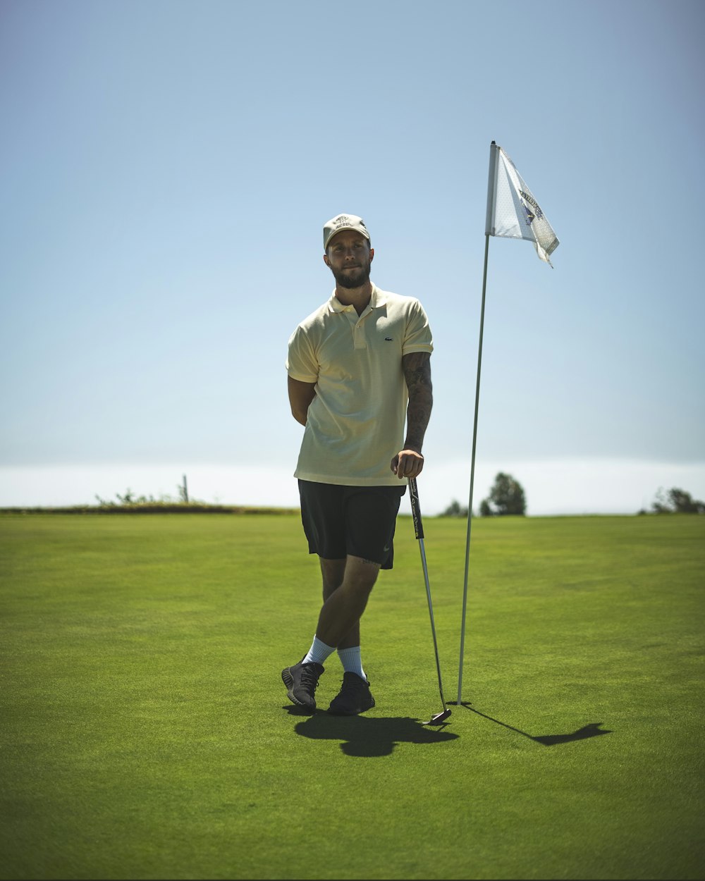 a man standing on top of a green field holding a golf club