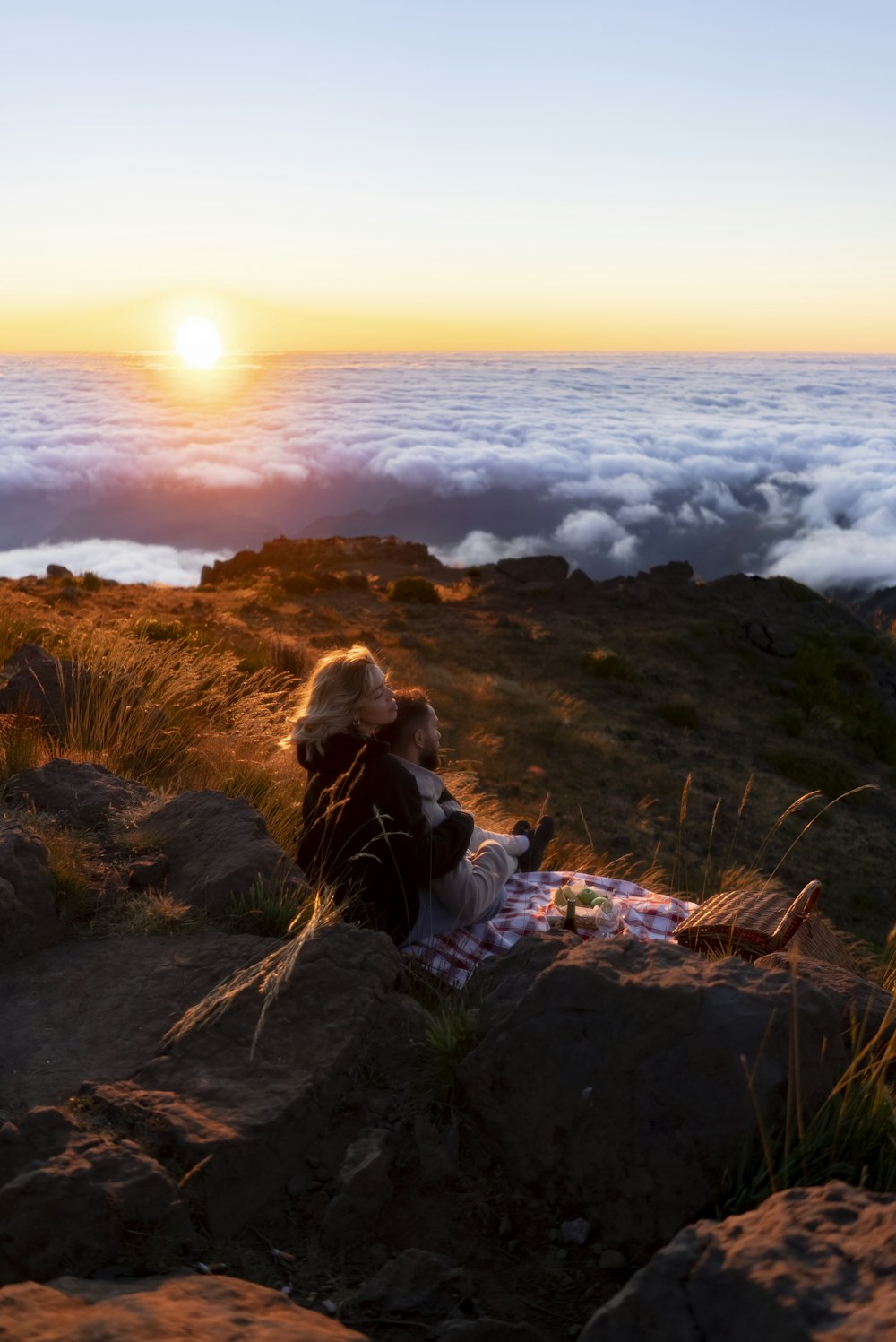a person sitting on top of a mountain with a blanket
