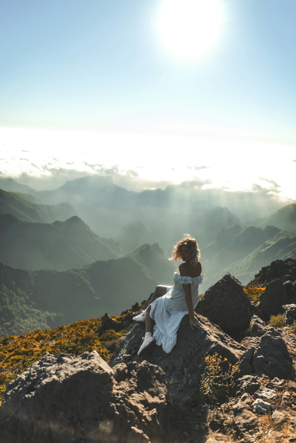 a woman sitting on top of a mountain