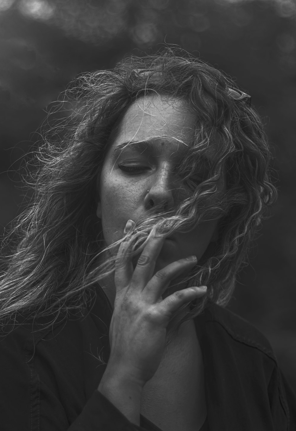 a woman smoking a cigarette in a black and white photo