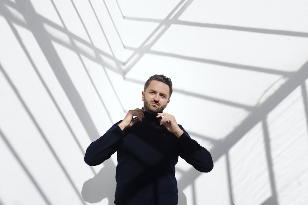 a man standing in front of a white wall