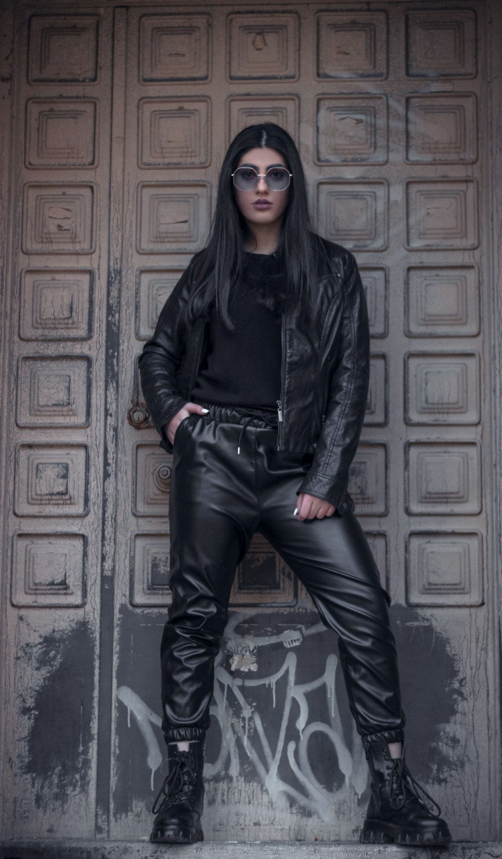 a woman wearing black leather pants and a leather jacket