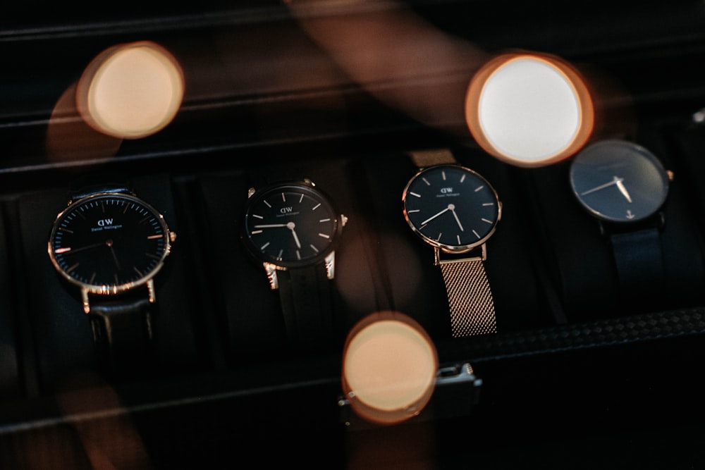 a group of three watches sitting on top of a table