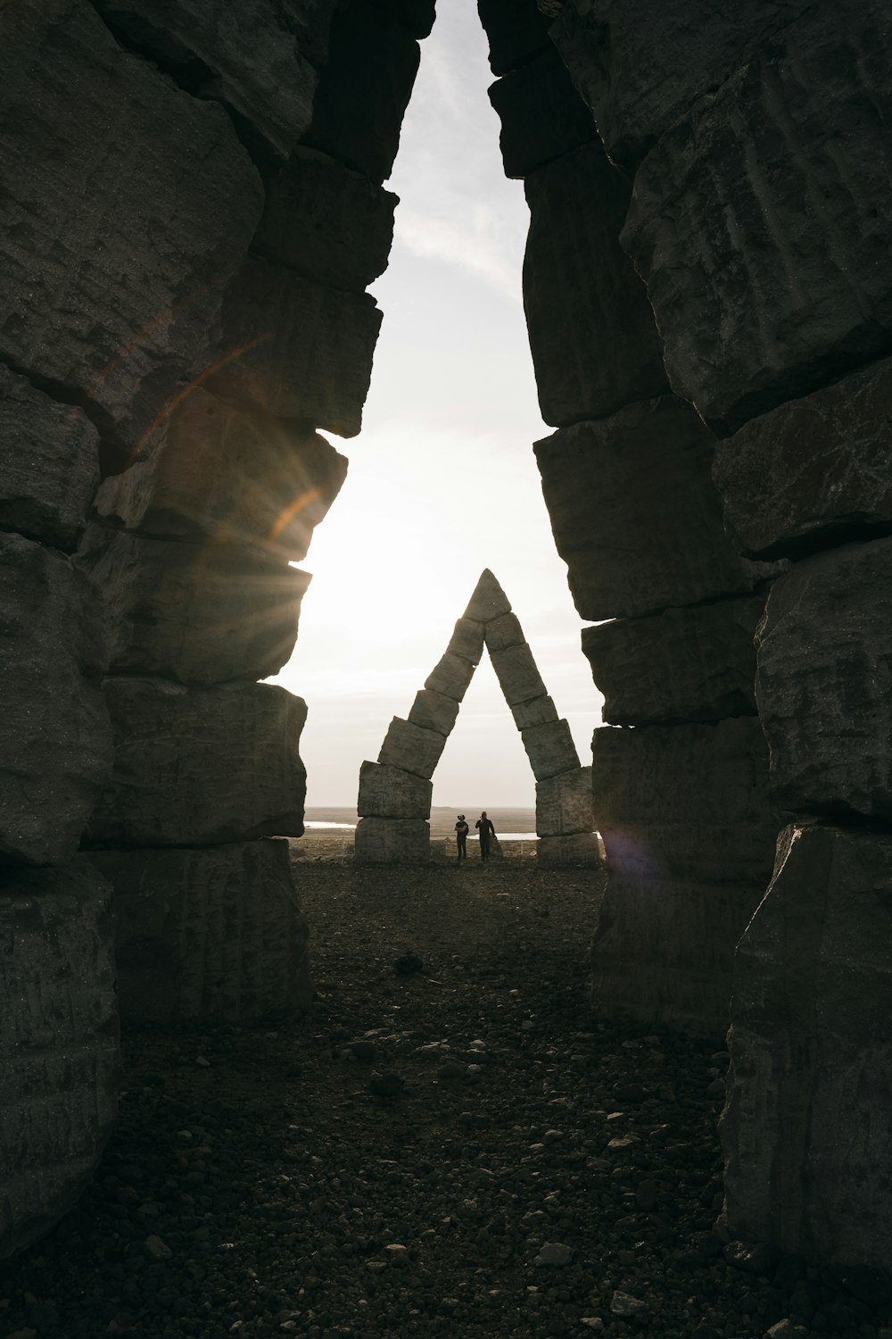 two people standing in the middle of a stone structure