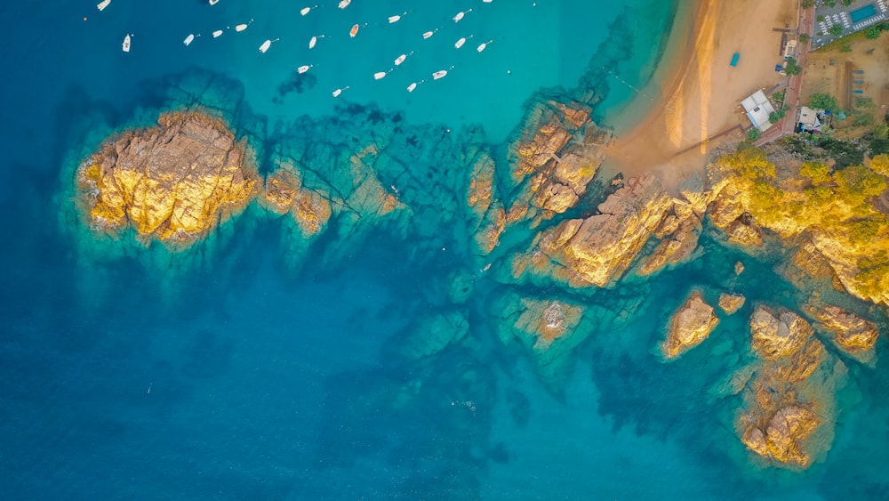 an aerial view of a beach with boats in the water