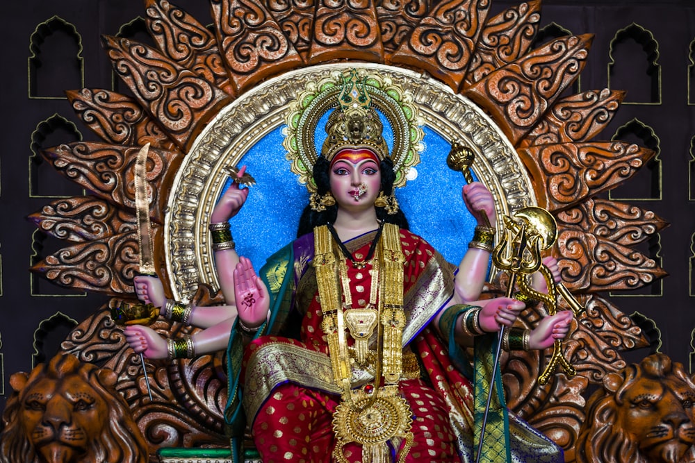 a statue of a woman sitting on top of a golden throne