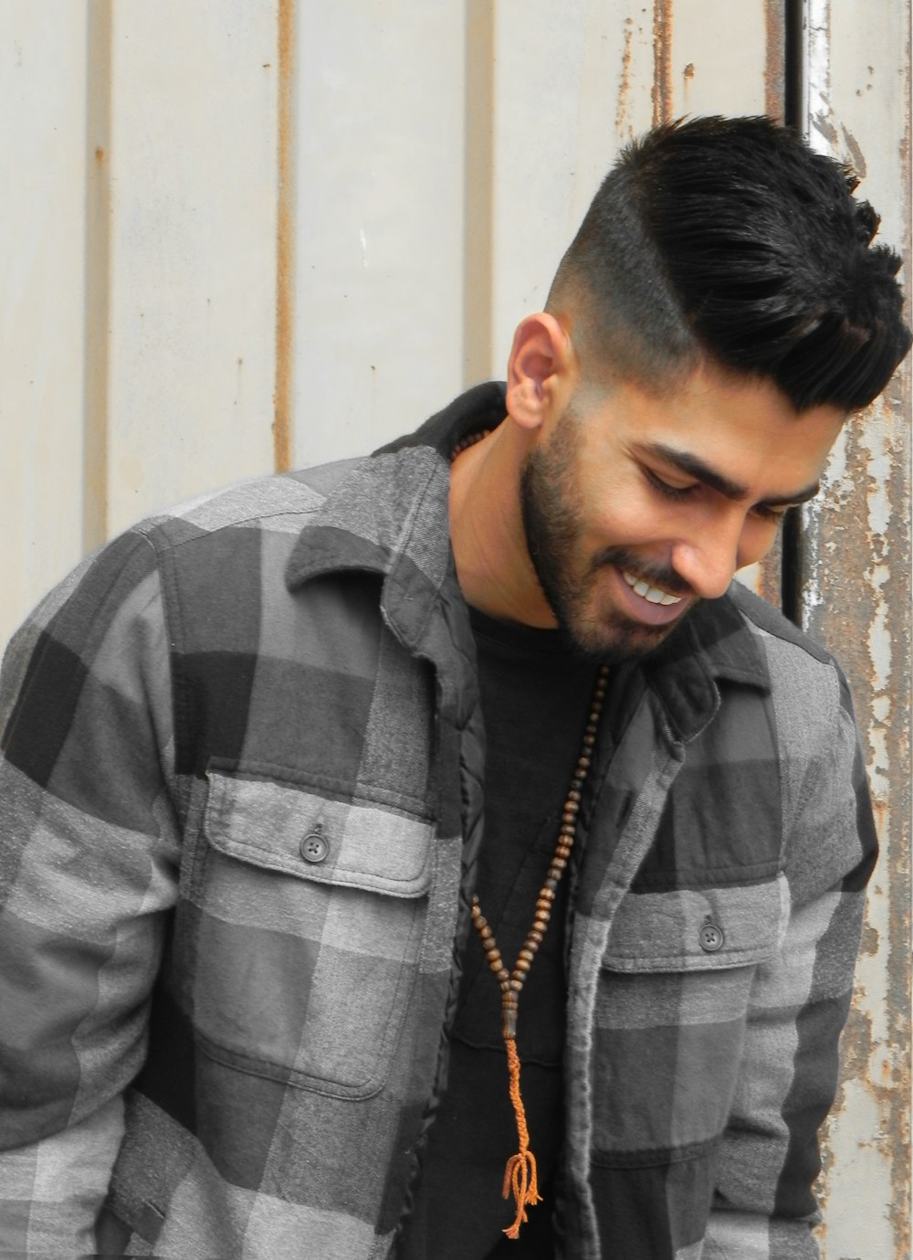 a man with a beard wearing a black and white checkered shirt