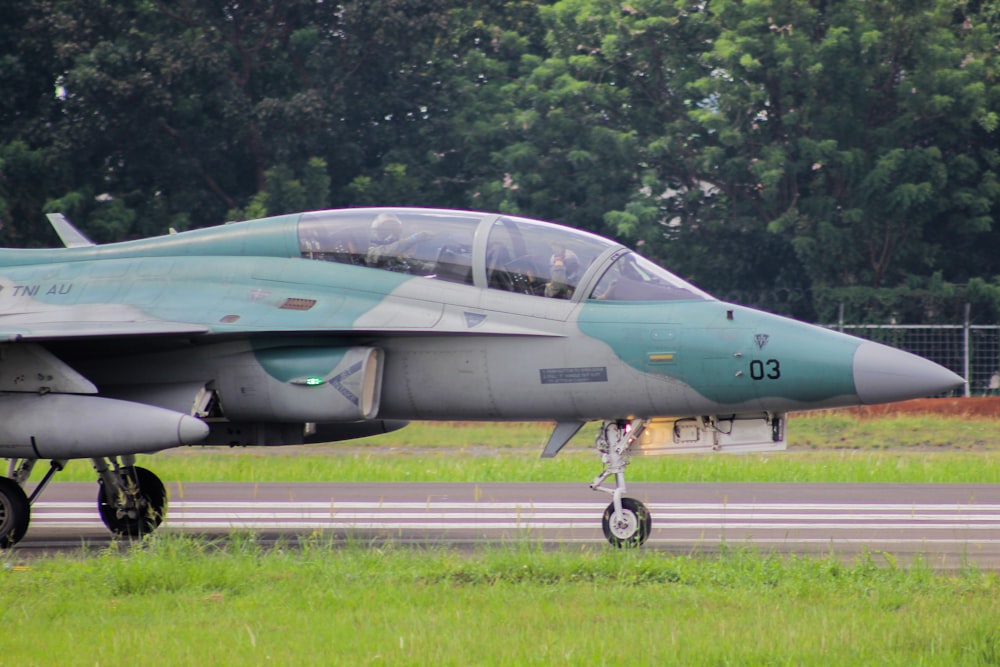 a fighter jet sitting on top of an airport runway